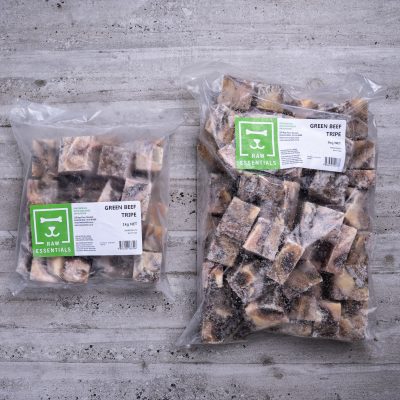 1kg Plastic Pack Of Frozen Cubed Green Beef Tripe Mix And 3kg Plastic Pack Of Frozen Cubed Green Beef Tripe Mix On Wooden Background
