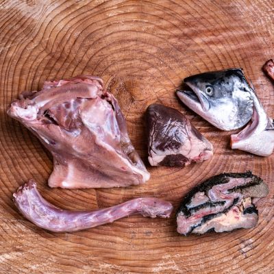 Assortment of Raw Essentials Ingredients Including,Turkey Neck, Tripe, Salmon Head, And Chicken Frame